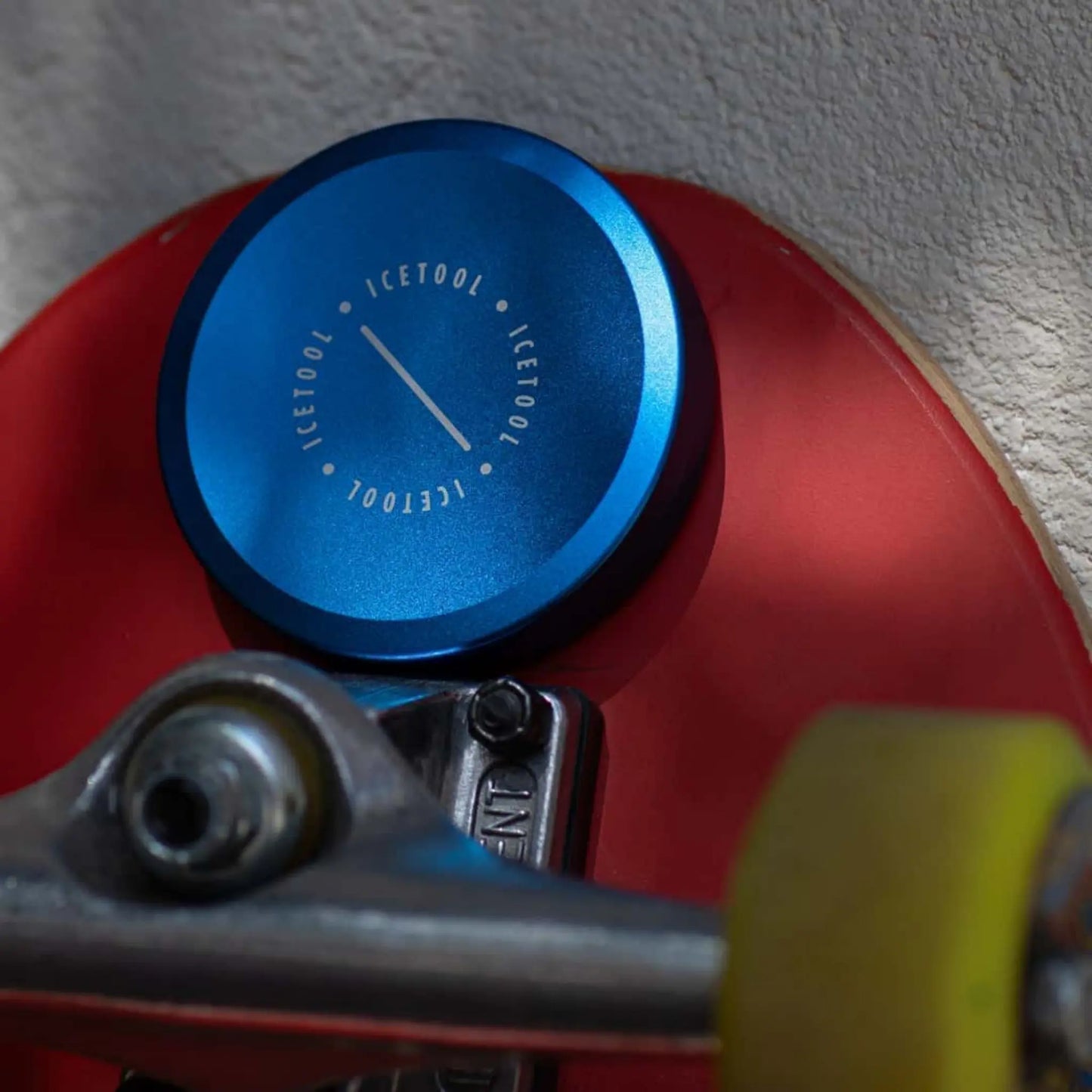 Blue metallic circular container on a red skateboard deck.