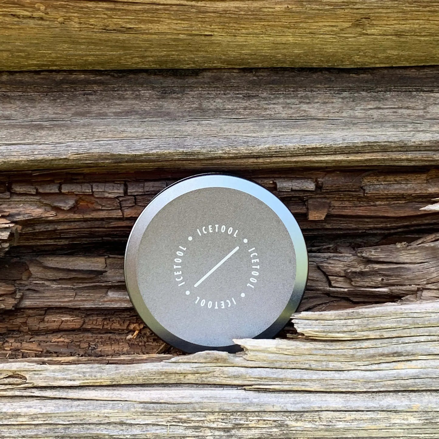 Silver circular container with a distressed wood background.