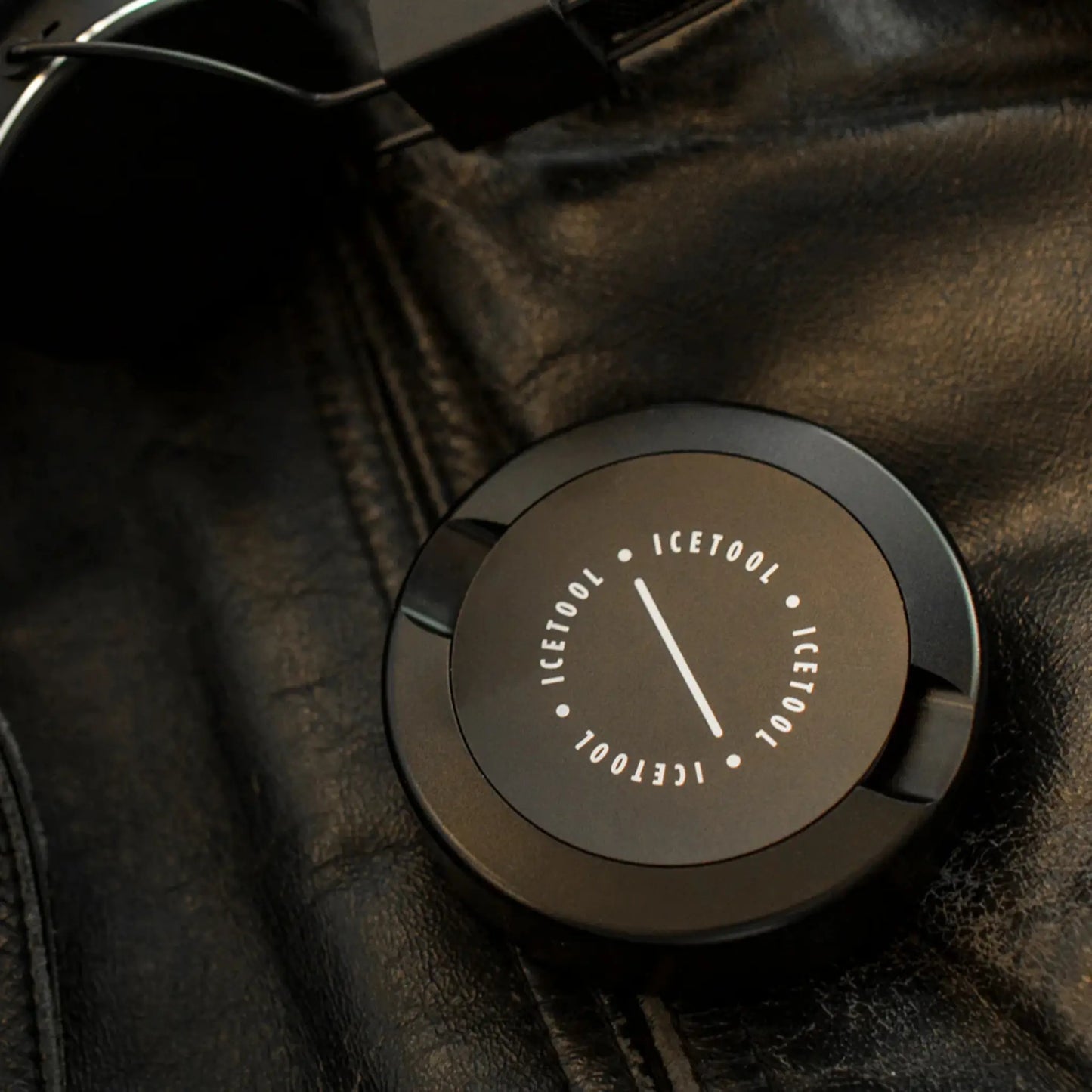 Black circular container with Icetool branding on a black leather jacket background.