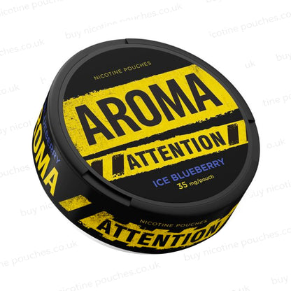 Angled shot of a black nicotine pouch container with yellow and blue Aroma Attention Ice Blueberry branding on a white background.