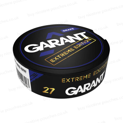 Angled shot of a black nicotine pouch container with purple, white and gold 'GARANT EXTREME EDITION GRAPE' branding on a white background.