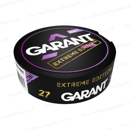 Angled shot of a black nicotine pouch container with purple, white and gold 'GARANT EXTREME EDITION ICE BLUEBERRY' branding on a white background.