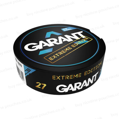 Angled shot of a black nicotine pouch container with cyan, white and gold 'GARANT EXTREME EDITION ICE COOL' branding on a white background.