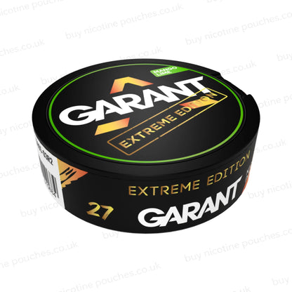 Angled shot of a black nicotine pouch container with green, white and gold 'GARANT EXTREME EDITION MANGO LIME' branding on a white background.