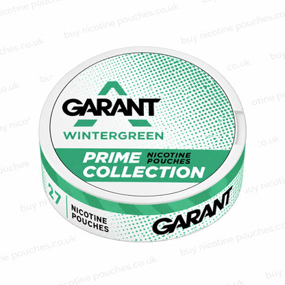 Angled shot of a white nicotine pouch can with green and black GARANT WINTERGREEN PRIME COLLECTION branding on a white, watermarked background.