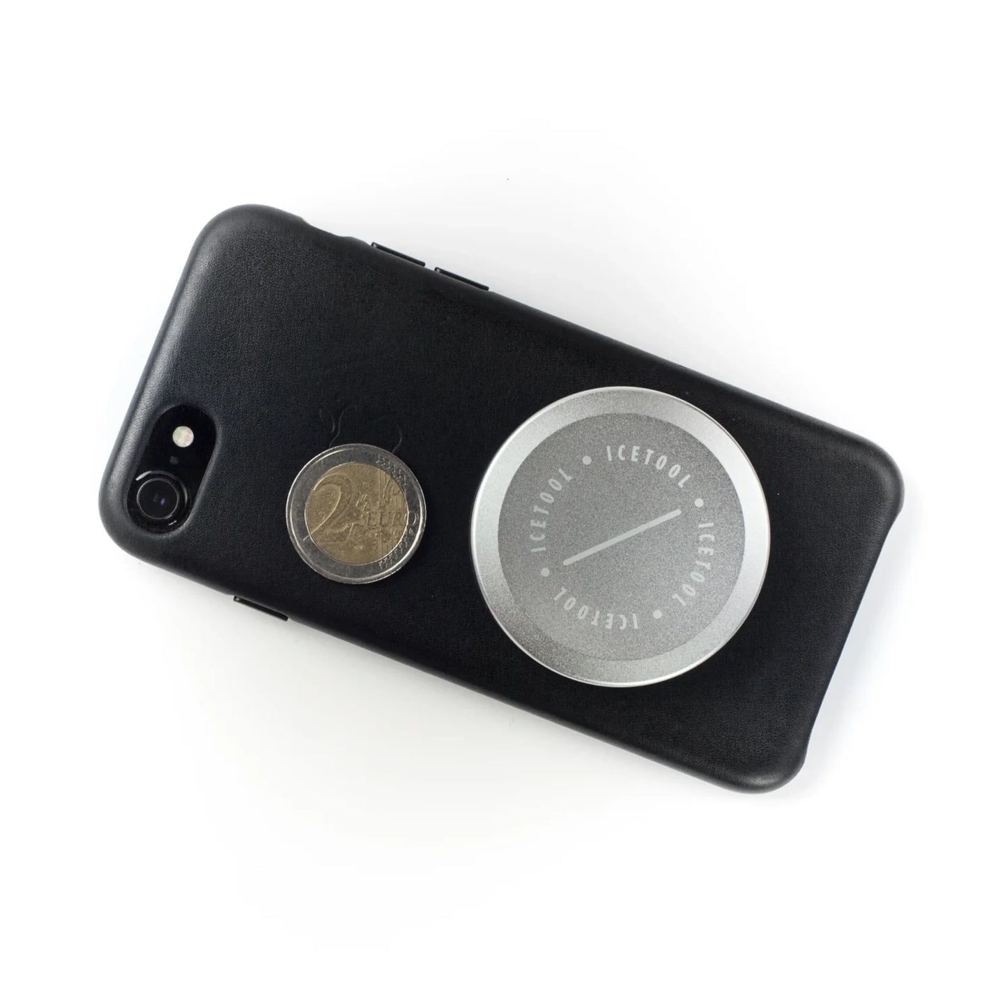 Silver metallic Icetool branded container and a coin on top of a phone.