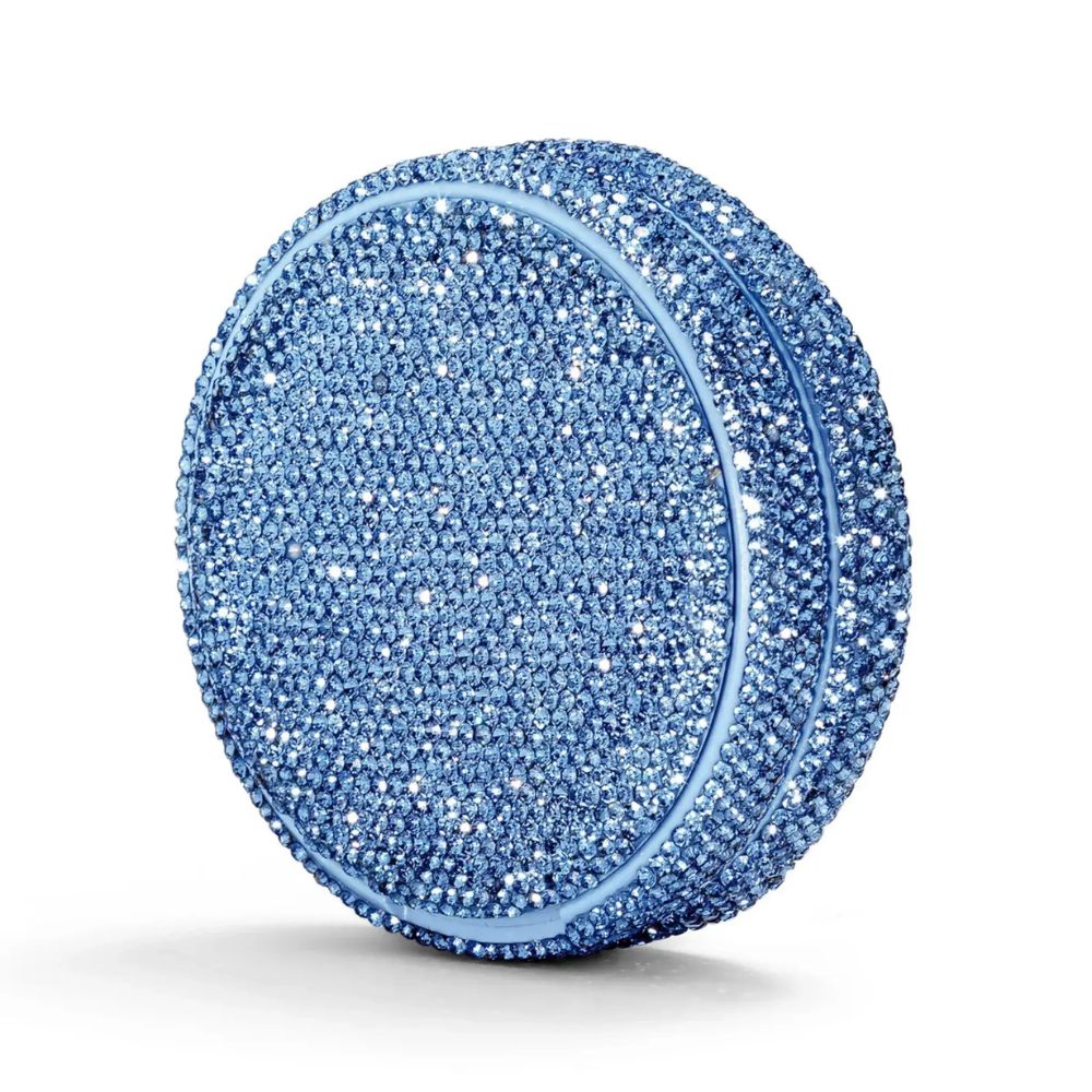 Angled shot of a circular container covered in blue rhinestones on a white background.