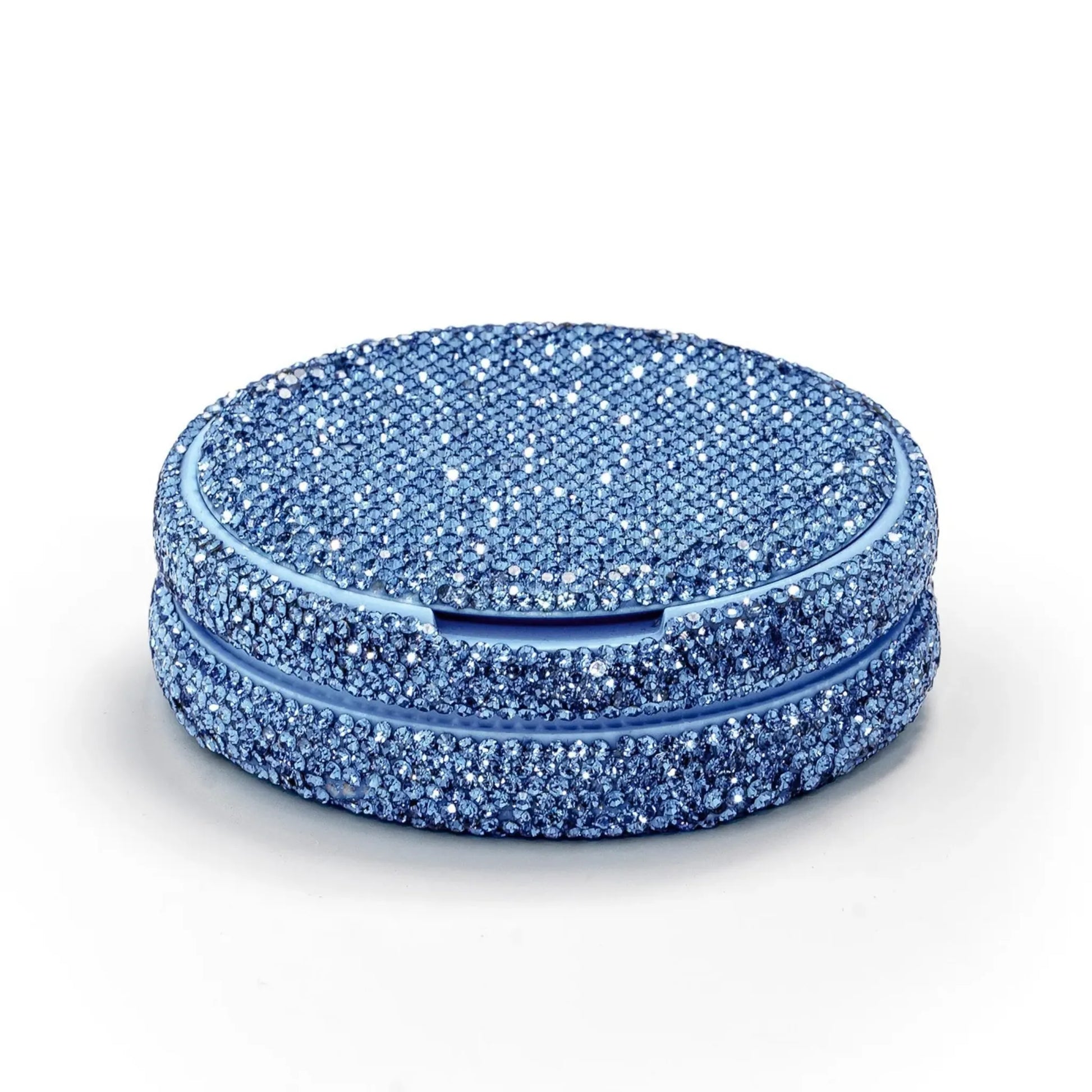 Angled shot of a circular container covered in blue rhinestones on a white background.