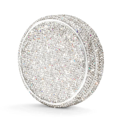 Angled shot of a circular container covered in silver rhinestones on a white background.