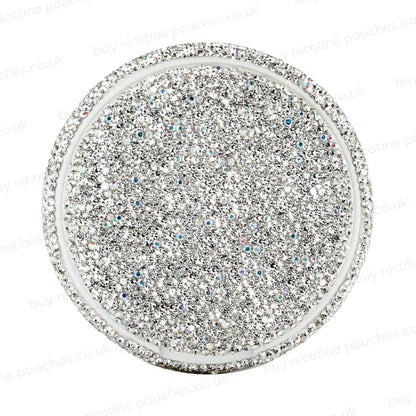 Silver circular container covered in rhinestones on a white background.